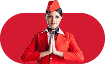 Frankfinn aviation training student in red uniform greeting with namaste gesture, representing cabin crew hospitality.